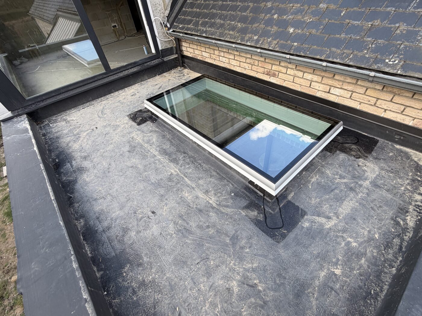 Terrasse couverte ossature bois avec toiture EPDM et puits de lumière — SikHabitat