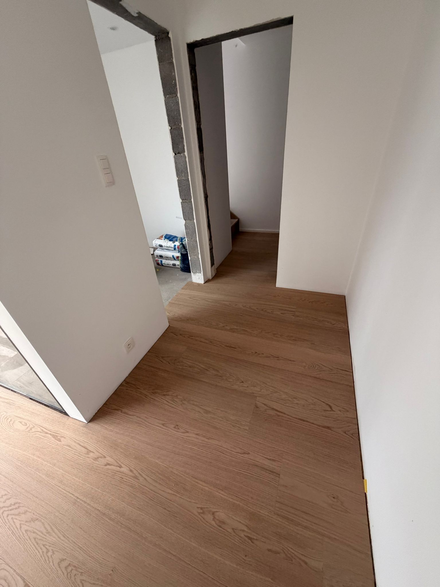 Couloir avec parquet posé — vue escalier